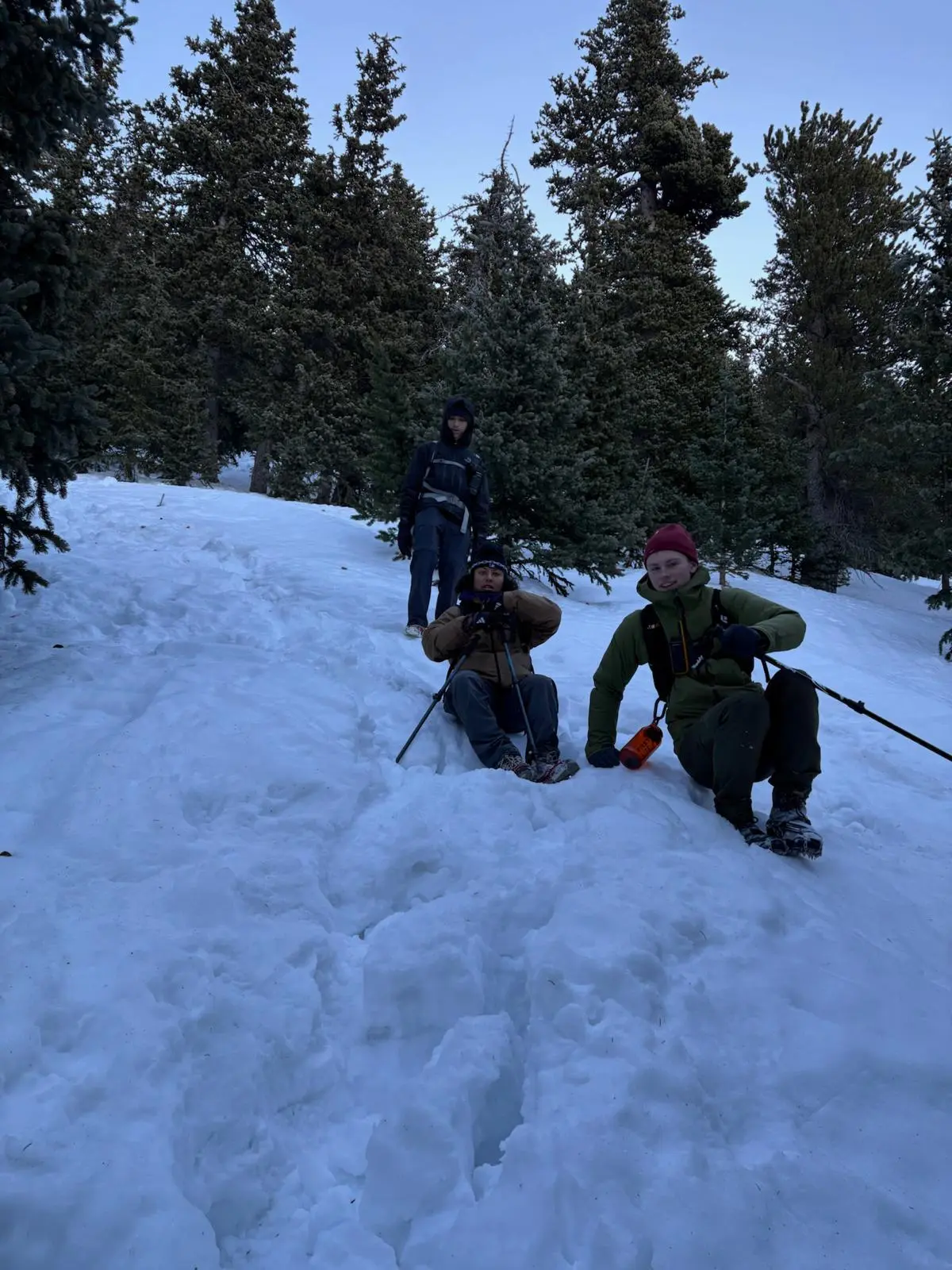 Three hikers moving together on a snowy mountain route